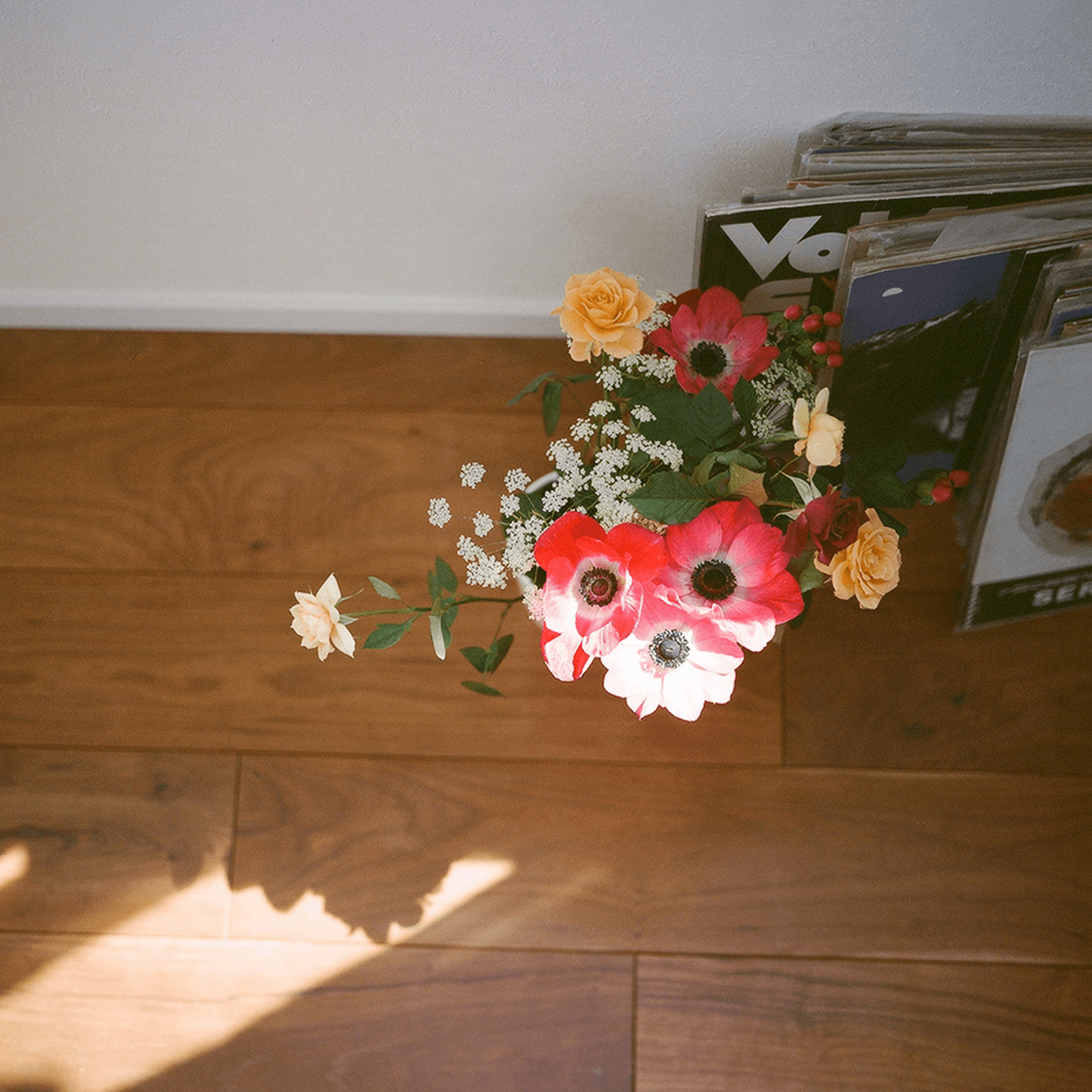 床に置かれた本と花の写真