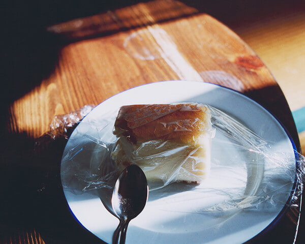ラップがかけられたチーズケーキの写真